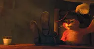 Kot w Butach (Antonio Banderas) przy stole przed wypiciem mleczka