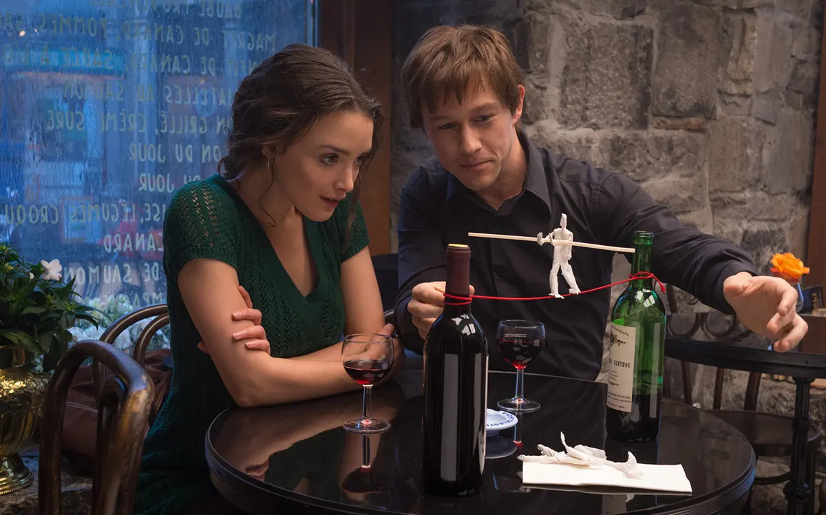 Joseph Gordon-Levitt z Charlotte Le Bon przy stole i lampce wina snuja plany spaceru po linie między wieżowcami World Trade Center